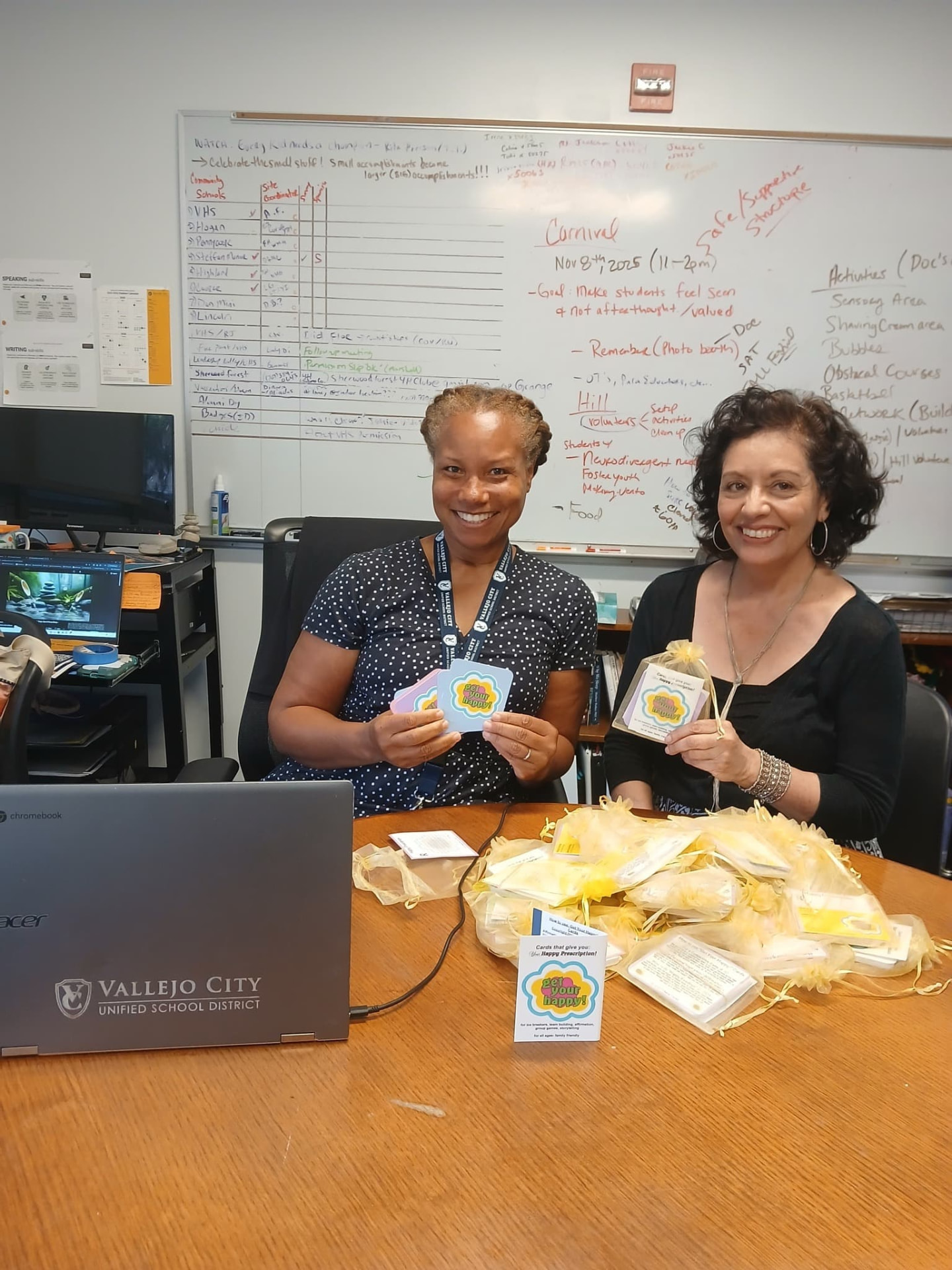 Diana Tenes with Cherita Dilley of Vallejo City Unified School District, alongside packaged Get Your Happy!® card sets.